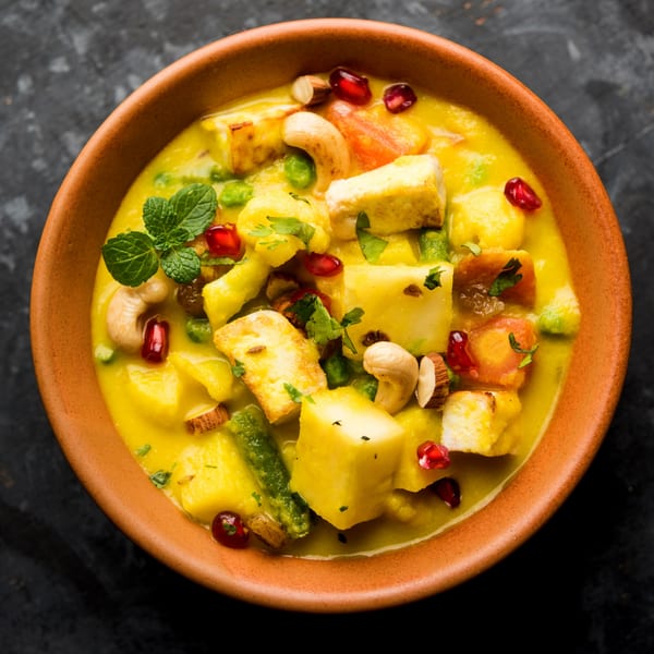 Close-up of Bombay Kitchen's Navratan Korma, a creamy Indian curry with paneer, fruits, and nuts.